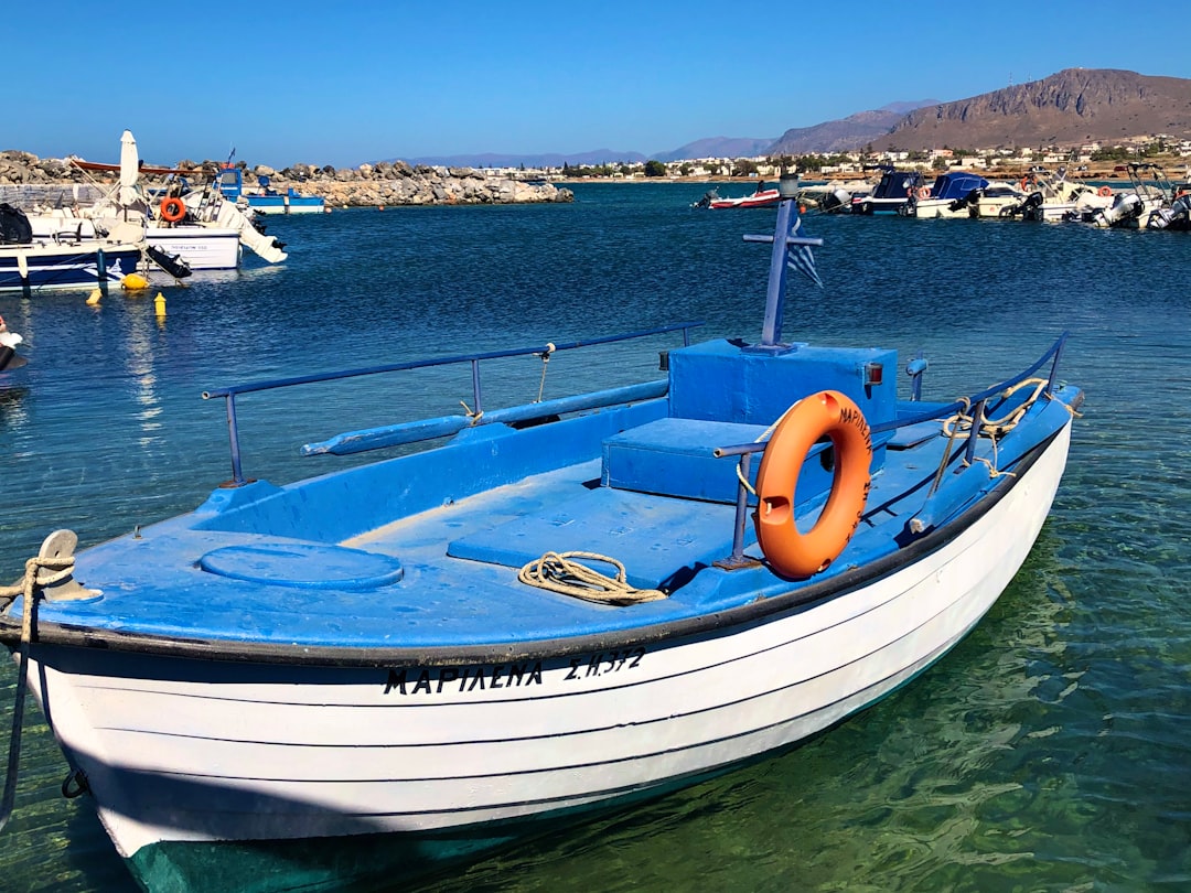 white and blue boat on sea during daytime