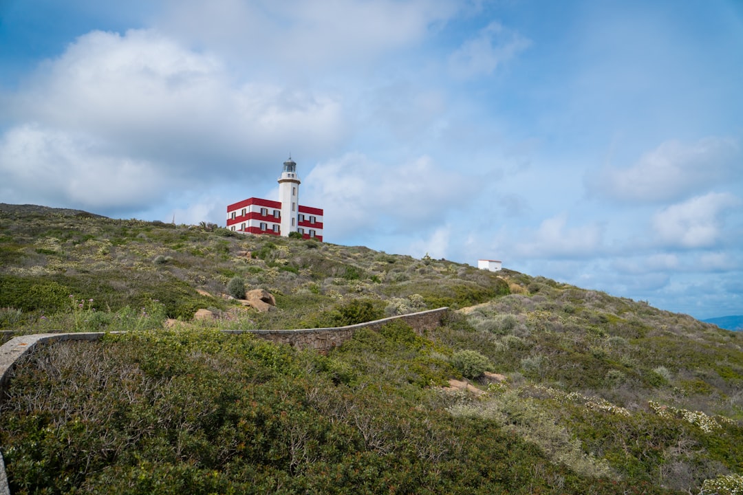 Lighthouse on a hill under a cloudy sky